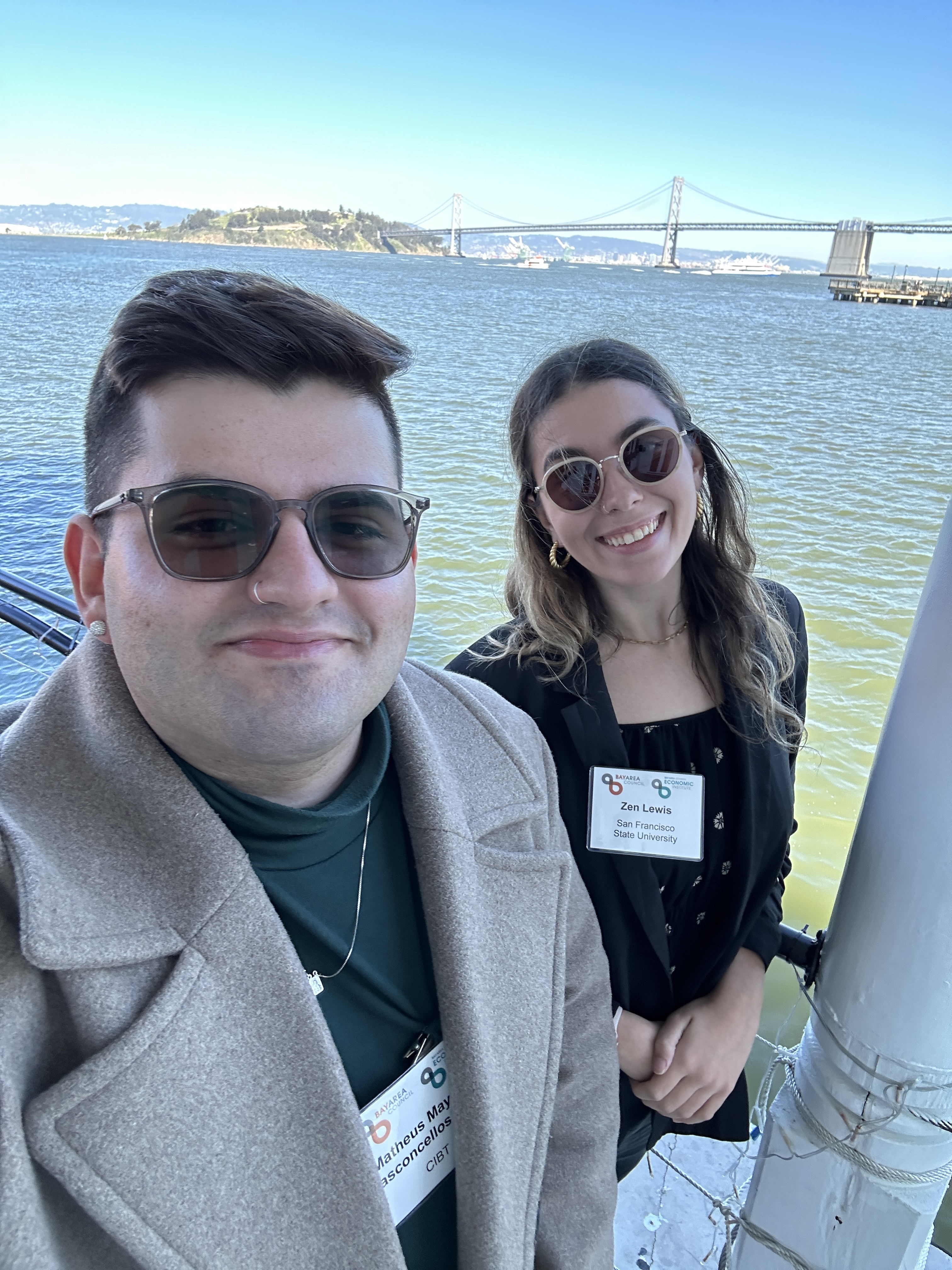 Two students stand in front of the San Francisco Bay, smiling into the camera.